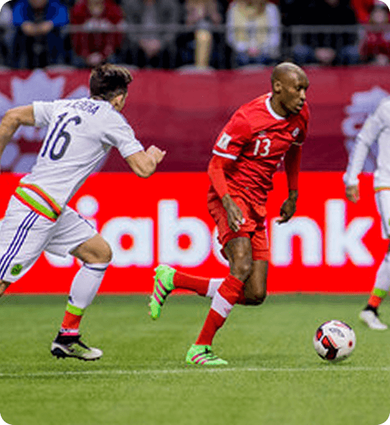 Atiba Hutchinson representing Canada in an international soccer match, mid-play with ball control