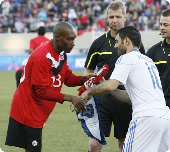 Atiba Hutchinson exchanging banners with opposing team captain before Canada’s international match